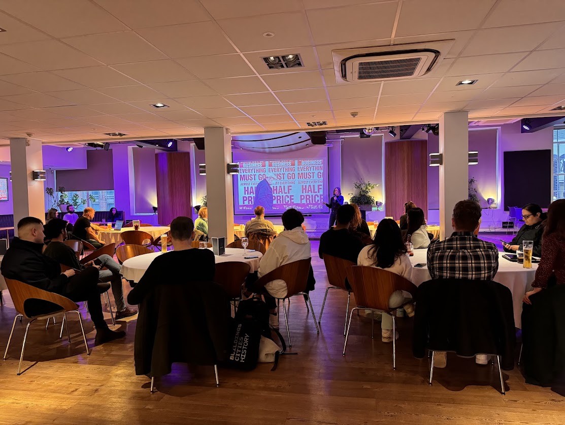 People at the tables listen to a talk