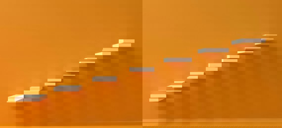 Stylised image of steps going up an orange wall